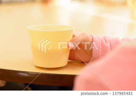 A toddler drinking from a cup; an image illustrating heatstroke prevention measures. 137985481