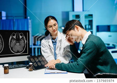 Female doctor comforting stressed male patient during medical consultation. Brain MRI scan, mental health diagnosis, healthcare support and modern medical technology. Female doctor comforting stressed male patient during medical consultation. Brain MRI scan, mental health diagnosis, healthcare support and modern medical technology. 137985974
