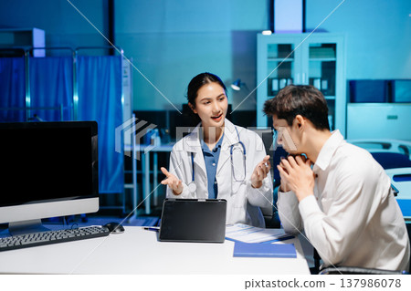 Asian doctor consulting patient in modern hospital office, explaining medical results and giving professional healthcare advice with friendly communication. Asian doctor consulting patient in modern hospital office, explaining medical results and giving professional healthcare advice with friendly communication. 137986078
