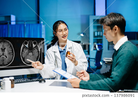 Doctor explains brain MRI scan to patient during medical consultation. Neurology, diagnosis, healthcare, medical imaging, treatment and modern hospital concept. 137986091