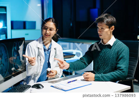 Doctor explains brain MRI scan to patient during medical consultation. Neurology, diagnosis, healthcare, medical imaging, treatment and modern hospital concept. 137986093