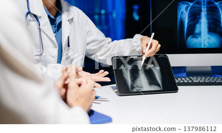 Professional female doctor explaining chest X-ray results to patient in modern clinic, medical consultation, radiology, healthcare, and diagnosis concept. Professional female doctor explaining chest X-ray results to patient in modern clinic, medical consultation, radiology, healthcare, and diagnosis concept. 137986112