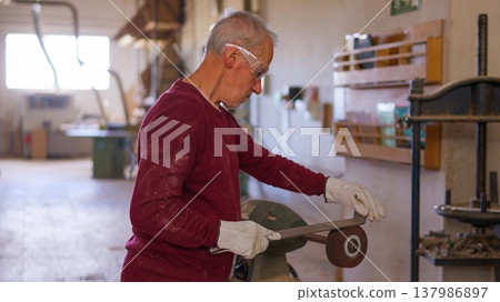 Senior craftsman working in workshop metal tube cutter machine Senior craftsman working in workshop metal tube cutter machine 137986897