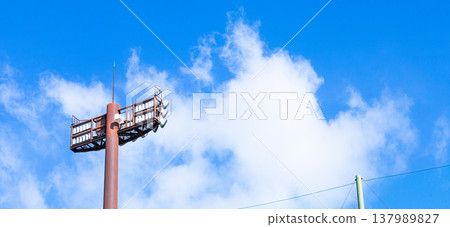 一幅簡單的畫面:湛藍的天空,潔白的雲朵,還有體育場的燈光。 一幅簡單的畫面:湛藍的天空,潔白的雲朵,還有體育場的燈光。 137989827