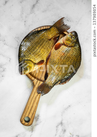 The fish are golden with distinct scales and fins, ready for cooking The fish are golden with distinct scales and fins, ready for cooking 137989854