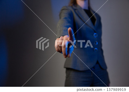 A portrait of a faceless woman in a business suit, holding her hand forward with her index finger raised. A warning gesture. Blue color correction A portrait of a faceless woman in a business suit, holding her hand forward with her index finger raised. A warning gesture. Blue color correction 137989919