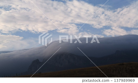 Misty waterfall in the mountains under a blue sky Misty waterfall in the mountains under a blue sky 137989969