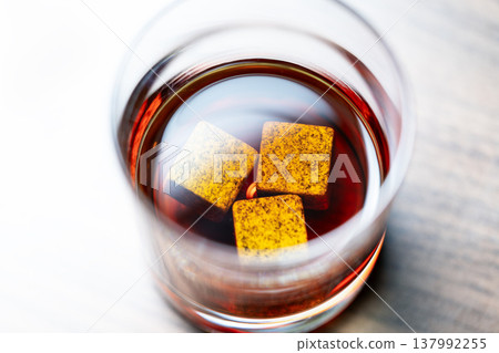 Whiskey glass with stones on wooden 137992255