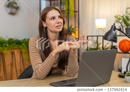 Young woman counts finished tasks on fingers folds digits reviews done list with calm focus indoors Young woman counts finished tasks on fingers folds digits reviews done list with calm focus indoors 137992814