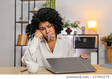 African American businesswoman tired closes laptop suddenly frustrated waves hand bored by dull work African American businesswoman tired closes laptop suddenly frustrated waves hand bored by dull work 137993175