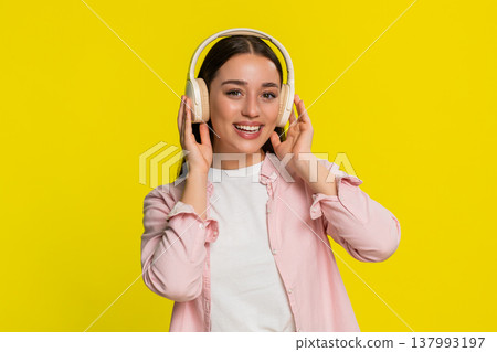 Woman dancing with closed eyes listening to music in headphones expressing carefree joyful emotion Woman dancing with closed eyes listening to music in headphones expressing carefree joyful emotion 137993197