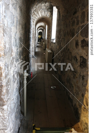 A historic building with a series of stone arches and a sense of perspective. 137993381
