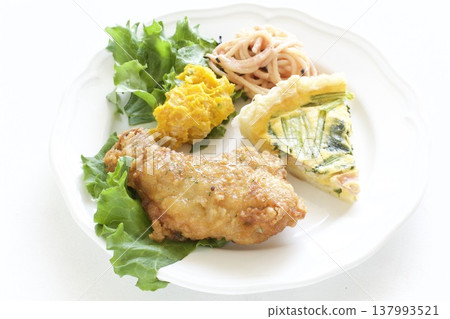 A one-plate meal of fried chicken and quiche. 137993521