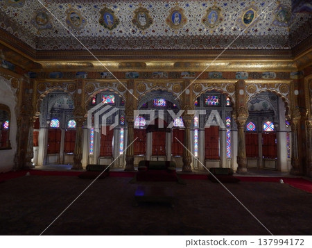 Ornate palace interior in Jodhpur featuring stained glass arched windows, intricate gold ceilings, and rich royal architecture. Ornate palace interior in Jodhpur featuring stained glass arched windows, intricate gold ceilings, and rich royal architecture. 137994172