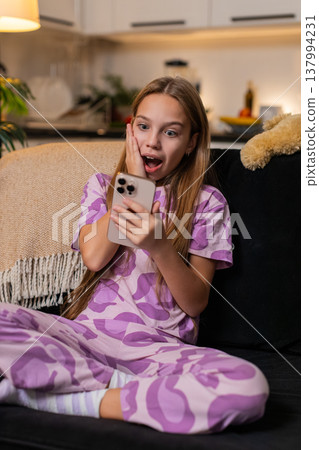 Teenager girl celebrates online game win on smartphone gets good news alert smiles cheers happy mood 137994231
