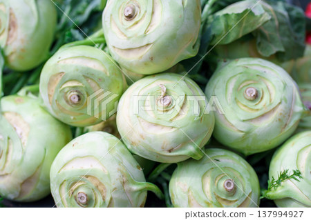 Fresh kohlrabi (Brassica oleracea var. gongylodes) bulbs at market stall, nutritious root vegetable, organic farming and healthy eating concept Fresh kohlrabi (Brassica oleracea var. gongylodes) bulbs at market stall, nutritious root vegetable, organic farming and healthy eating concept 137994927