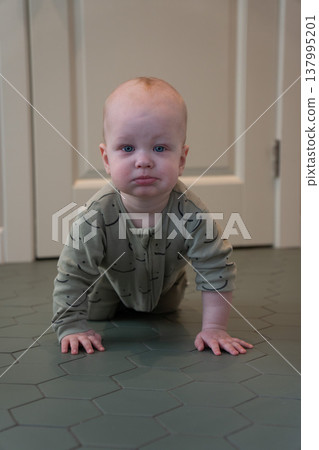 Baby crawls on floor in home interior with soft light and minimal setting, early development stage and exploration in everyday domestic environment. Child development, parenting content, family Baby crawls on floor in home interior with soft light and minimal setting, early development stage and exploration in everyday domestic environment. Child development, parenting content, family 137995201