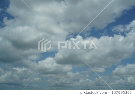 Clouds Against a Blue Sky on a Sunny Day Clouds Against a Blue Sky on a Sunny Day 137995393