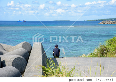 An elderly man gazing at the blue sea. 137995631