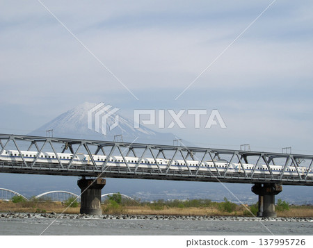 Viewing the Shinkansen and Mount Fuji from the riverbank. Viewing the Shinkansen and Mount Fuji from the riverbank. 137995726