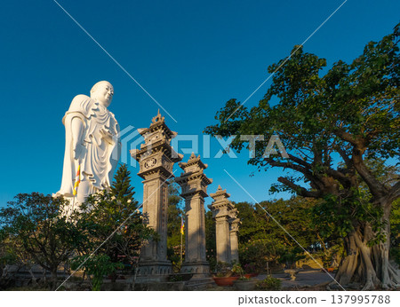 Standing Buddha statue against sky at Tong Lam Son Temple Nha Trang Vietnam Standing Buddha statue against sky at Tong Lam Son Temple Nha Trang Vietnam 137995788