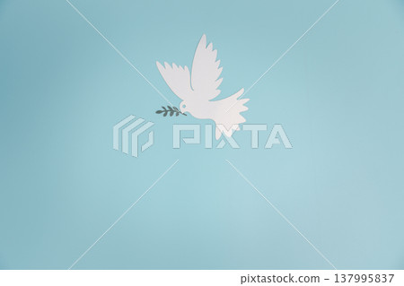 Minimal paper-cut white dove carrying an olive branch flying in soft blue sky with clouds and subtle peace sign, copy space for message, symbol of harmony, hope and unity, ideal for Peace Day. Minimal paper-cut white dove carrying an olive branch flying in soft blue sky with clouds and subtle peace sign, copy space for message, symbol of harmony, hope and unity, ideal for Peace Day. 137995837