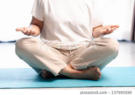 Close-up of hands in yoga meditation mudra during mindfulness practice, soft bright background with copy space. Calm wellness concept for relaxation, breathing, zen and mental health. 137995890