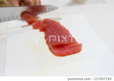 Cut the tuna lean meat fillet. 137997199