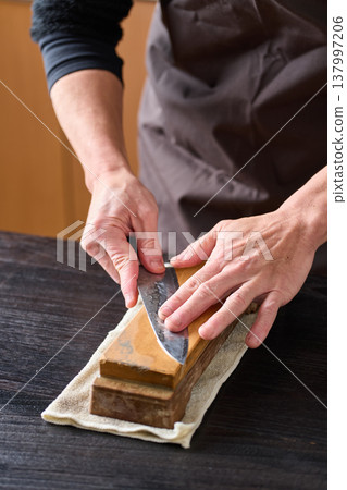 Man sharpening a knife 137997206
