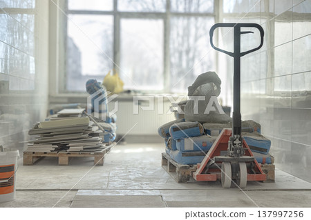 Construction Materials and Pallet Jack in Renovation Interior with Natural Light Construction Materials and Pallet Jack in Renovation Interior with Natural Light 137997256
