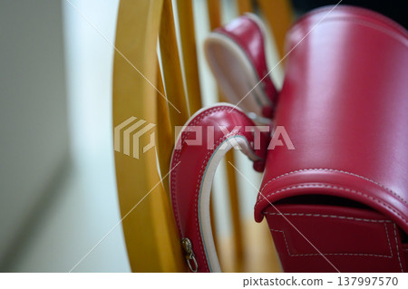 A red school bag hanging on a chair A red school bag hanging on a chair 137997570