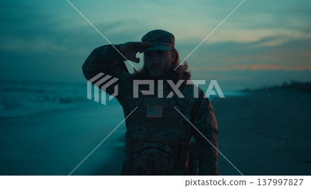 Silhouette of an American soldier saluting near the stormy ocean At Memorial Day Silhouette of an American soldier saluting near the stormy ocean At Memorial Day 137997827