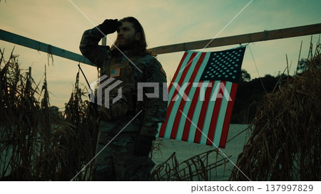 American flag on Memorial Day and soldier honoring fallen soldiers in desert American flag on Memorial Day and soldier honoring fallen soldiers in desert 137997829