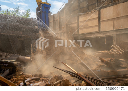 Demolition work on an old vacant house: Dust control measures using water spraying. 138000471
