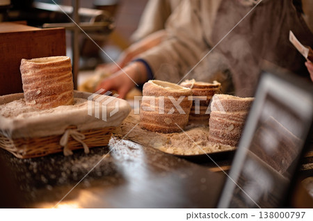 Freshly baked cylindrical pastries dusted with flour on wooden table in bakery setting Freshly baked cylindrical pastries dusted with flour on wooden table in bakery setting 138000797