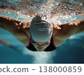 Swimmer diving into clear water, showcasing powerful strokes and dynamic movement in aquatic environment 138000859