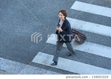 A Japanese businesswoman in her 30s moves around town with a suitcase. A Japanese businesswoman in her 30s moves around town with a suitcase. 138001029
