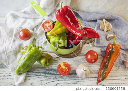 Fresh colorful bell peppers, tomatoes and garlic on wooden table for cooking, organic farm vegetables Fresh colorful bell peppers, tomatoes and garlic on wooden table for cooking, organic farm vegetables 138001356