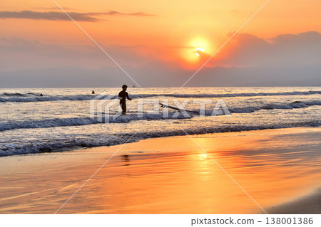 Surfers emerge from Kugenuma Beach, bathed in the sunset light. Surfers emerge from Kugenuma Beach, bathed in the sunset light. 138001386