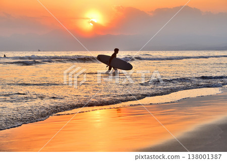 Surfers emerge from Kugenuma Beach, bathed in the sunset light. Surfers emerge from Kugenuma Beach, bathed in the sunset light. 138001387