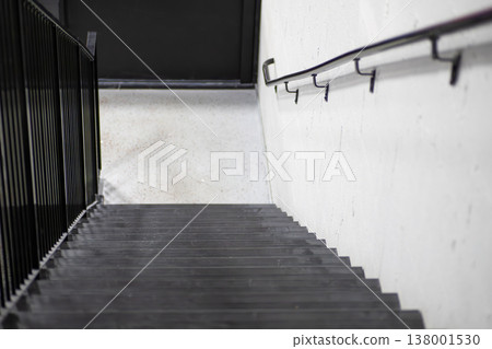 A monochrome staircase with a handrail 138001530