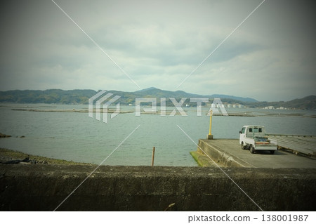 一輛輕型卡車停在港口,遠處有牡蠣養殖的海景。 一輛輕型卡車停在港口,遠處有牡蠣養殖的海景。 138001987