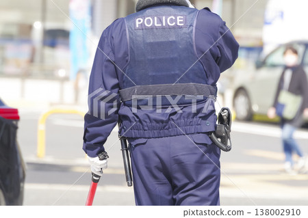 一名警察正在城市指揮交通。 一名警察正在城市指揮交通。 138002910