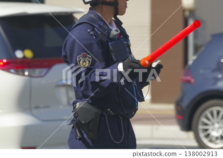 一名警察正在城市指揮交通。 一名警察正在城市指揮交通。 138002913