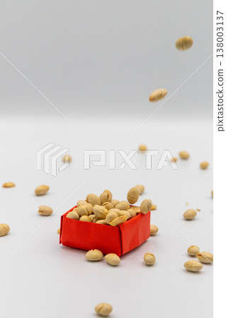 A Setsubun bean-throwing image with beans raining down onto a red origami box, against a white background. A Setsubun bean-throwing image with beans raining down onto a red origami box, against a white background. 138003137