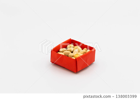 Soybeans in a red origami box, reminiscent of lucky beans for Setsubun (bean-throwing festival), against a white background. 138003399