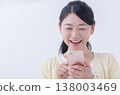 A young woman operating a smartphone 138003469