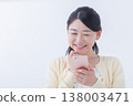 A young woman operating a smartphone 138003471