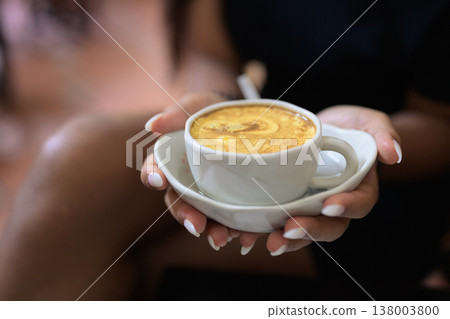 Hot Vietnamese Egg Coffee in Cup Held by Young Asian Woman 138003800