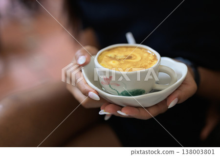 Hot Vietnamese Egg Coffee in Cup Held by Young Asian Woman 138003801